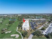 An aerial view of a well-maintained condo building surrounded by lush landscaping and a golf course at 6120 43Rd W St # 103B, Bradenton, FL 34210