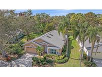 Charming single-story home with a well-manicured front yard, mature landscaping, and a view of a serene pond at 7312 Eleanor Cir, Sarasota, FL 34243