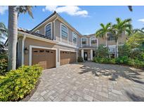 Stunning two-story home featuring a three-car garage, beautiful landscaping, and a brick paved driveway at 820 Placid Lake Dr, Osprey, FL 34229