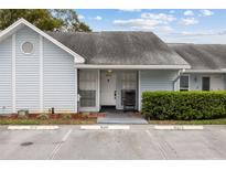 Charming light blue townhome with a rocking chair on the front porch and assigned parking spaces at 16211 Rambling Vine W Dr, Tampa, FL 33624
