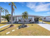 Charming single-story home with manicured lawn, walkway, and a covered parking in a well-maintained community at 1874 Woodstock Ln, Sarasota, FL 34234