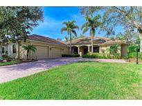 Beautiful single-story home featuring a three-car garage and a brick driveway in a verdant setting at 3751 Eagle Hammock Dr, Sarasota, FL 34240