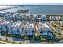 Stunning aerial view of waterfront condominiums with beautiful landscaping and water views in a coastal community at 383 Aruba Cir # 102, Bradenton, FL 34209