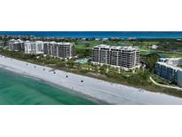 An aerial view of high-rise condos on the beach, next to manicured golf courses, with turquoise gulf water at 415 L Ambiance Dr # D606, Longboat Key, FL 34228