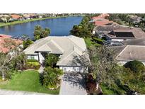 A waterfront single Gathering home boasts mature landscaping and tile roof in an established neighborhood at 4941 Sabal Lake Cir, Sarasota, FL 34238