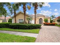 Charming single-story home featuring a well-manicured lawn, paver driveway, and lush tropical landscaping at 5539 Octonia Pl, Sarasota, FL 34238