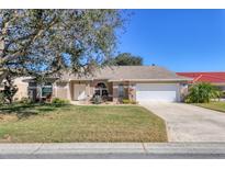 Charming single-story home featuring a manicured lawn, inviting entrance and attached two car garage at 6911 Stetson Street Cir, Sarasota, FL 34243