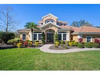 Stunning two-story home with a tile roof, manicured lawn, and lush landscaping under a clear blue sky at 6919 Winners Cir, Lakewood Ranch, FL 34202