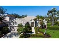 Charming single-story home featuring lush landscaping, a beige exterior, and a welcoming walkway at 8803 18Th Nw Ave, Bradenton, FL 34209