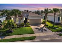 Beautiful single-Gathering home featuring a tile roof, palm trees, and a well-manicured front lawn at 12326 Blue Hill Trl, Bradenton, FL 34211