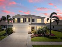 Charming two-story home features a manicured lawn, lush landscaping, and a two-car garage at 12716 Dusty Trail Dr, Sarasota, FL 34238