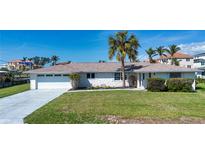 Charming single-story home with a well-manicured lawn and a large palm tree in the front yard at 1541 Shelburne Ln, Sarasota, FL 34231