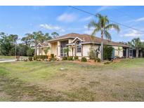 Charming home boasts lush landscaping, a neutral color scheme, and lovely architectural detailing at 17368 Norseman Ave, Port Charlotte, FL 33948