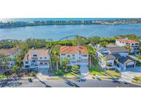 Stunning waterfront home features a Mediterranean-style design with a red tile roof and lush tropical landscaping at 3491 Bayou Sound, Longboat Key, FL 34228