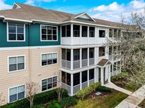Three-story condo building with screened lanais, colorful siding, landscaping, and walkway at 4802 51 W St # 1017, Bradenton, FL 34210