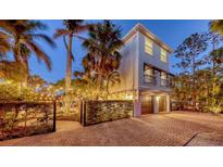 Charming two-story home with two-car garage, brick driveway and beautifully landscaped yard with mature palm trees at 601 Avenida De Mayo, Sarasota, FL 34242