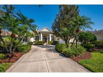 Beautiful home featuring a well-manicured lawn, decorative palms, and a long driveway leading to a welcoming entrance at 7015 Stanhope Pl, University Park, FL 34201