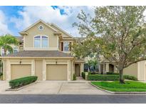 Charming townhouse featuring a tan facade, two-car garage, and manicured landscaping at 8043 St Simons St, Bradenton, FL 34201