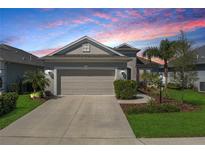 Charming one-story home featuring a two-car garage, well-manicured landscaping, and a welcoming front facade at 10914 Blue Magnolia Ln, Parrish, FL 34219