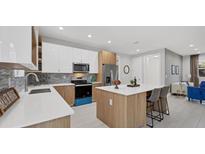 Bright kitchen features modern appliances, breakfast bar, and white and wood cabinetry at 1313 Kacerik St, North Port, FL 34288