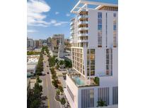 Modern, multi-story building with pool and rooftop deck overlooking the cityscape and bright blue skies at 1703 Main St # 1205, Sarasota, FL 34236