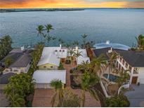 Stunning waterfront home with a metal roof, lush landscaping, and a private dock on a tranquil bay at 204 N Washington Dr, Sarasota, FL 34236