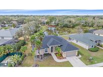 An aerial view of a single Gathering home with palm trees near a pond and lush landscaping at 2260 Island Creek Rd, Sarasota, FL 34240