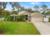 Well-maintained single-Gathering home with a lush green lawn and mature palm trees at 3007 Goodwater St, Sarasota, FL 34231