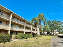 Three-story condo building featuring multiple balconies, manicured lawns, and vibrant green shrubbery at 3987 Maceachen Blvd # 132, Sarasota, FL 34233