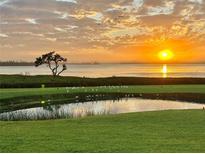 Scenic water view with a tree-lined landscape and a vibrant sunset, creating a serene and picturesque scene at 4734 Independence Dr # 4734, Bradenton, FL 34210