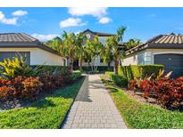 Beautifully landscaped villa with palm trees and a brick pathway leading to the entrance at 5537 Palmer Cir # 205, Lakewood Ranch, FL 34211
