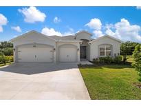 Charming single-story home with a three-car garage, well-manicured lawn, and welcoming front entrance at 6506 166Th E Pl, Parrish, FL 34219