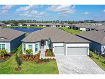 Beautiful single Gathering home with a manicured lawn, paver driveway and a tranquil lake view at 9028 Sunray Cv, Parrish, FL 34219
