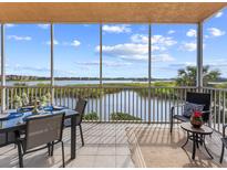 This patio features a dining set and seating with scenic water views and tile flooring at 10520 Boardwalk Loop # 205, Lakewood Ranch, FL 34202