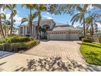 Stunning luxury home boasting meticulous landscaping, a paved driveway, and an attached three-car garage at 121 N Boulevard Of Presidents, Sarasota, FL 34236