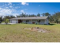 Charming single-story home with a gray exterior, lush green lawn, and an attached two-car garage at 1510 Lena Ln, Sarasota, FL 34240