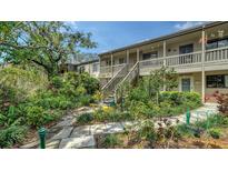 Charming condo exterior featuring lush landscaping and inviting walkways at 1601 Pelican Point Dr # 212, Sarasota, FL 34231