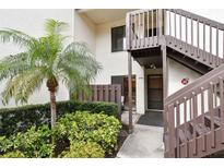 Inviting condo exterior featuring a well-manicured lawn, mature palm tree, and private entrance stairs at 2774 71St St Ct W # 2101, Bradenton, FL 34209