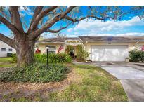 Charming single-story home with a well-manicured lawn, mature trees, and an attached two-car garage at 4050 Oakhurst Dr # 3175, Sarasota, FL 34233
