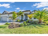 Beautiful single-story home features lush landscaping, well manicured lawn, and a two-car garage at 4813 Sparkling Sea Ln, Lakewood Ranch, FL 34211