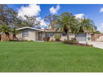 Beautiful single-story home featuring a well-manicured front lawn and mature palm trees, perfect for curb appeal at 3053 Concord St, Sarasota, FL 34231