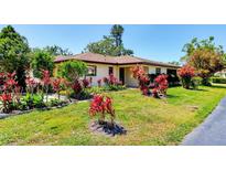 Charming single-story home with a well-manicured lawn and vibrant landscaping at 3208 Vivienda Blvd, Bradenton, FL 34207