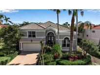 Charming home featuring tropical landscaping, a tile roof, and an attached two-car garage at 3617 Fair Oaks Pl, Longboat Key, FL 34228