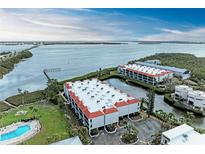 Beautiful waterfront condo complex featuring a swimming pool and well-maintained landscaping at 3805 E Bay Dr # 301, Holmes Beach, FL 34217