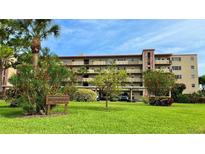 Exterior view of building with well maintained lawn, greenery and unit parking at 4460 Ironwood Cir # 505Ad, Bradenton, FL 34209