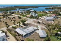 Gorgeous aerial view of coastal property with mature landscaping and waterways, featuring a private drive and metal roof at 45 Cape Haze Dr, Placida, FL 33946