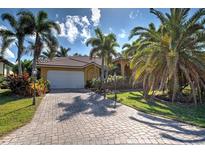 Long brick driveway leads up to the house, beautiful green lawn and many palm trees at 5007 Palermo Dr, Punta Gorda, FL 33950