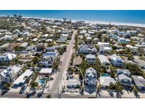 Aerial view of a charming coastal community with a beach, and white home near the ocean at 701 N Bay Blvd, Anna Maria, FL 34216
