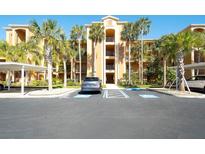 A multi-story condo building with palm trees and designated accessible parking at 8403 Grand Estuary Trl # 103, Bradenton, FL 34212