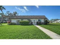 Charming single story home featuring a well-manicured lawn and a neatly landscaped yard at 1310 Grand Blvd # 202, Sarasota, FL 34232
